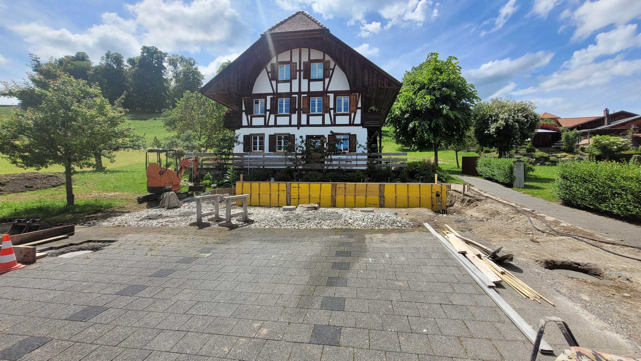 Baustelle vor einem Berner Bauernhaus im Dorf.